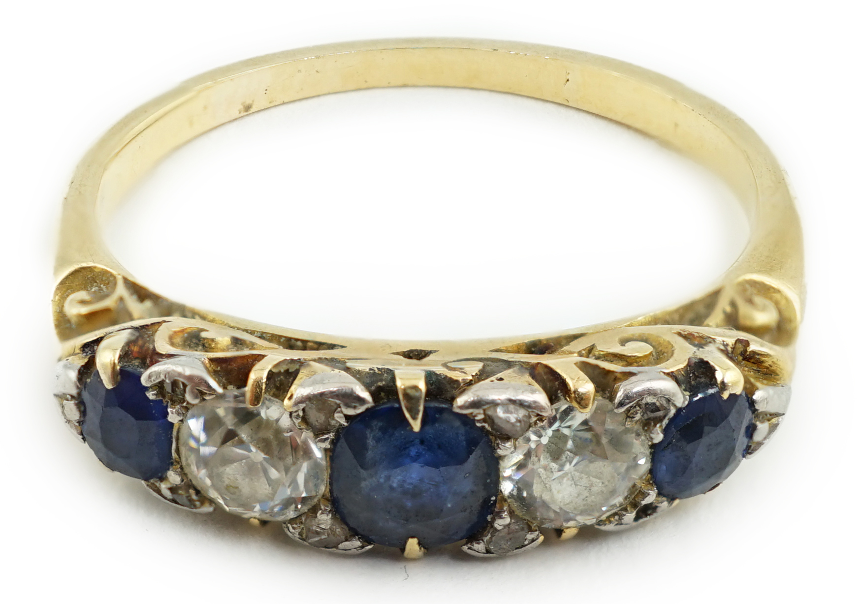 A gold, three stone sapphire and two stone diamond set half hoop ring